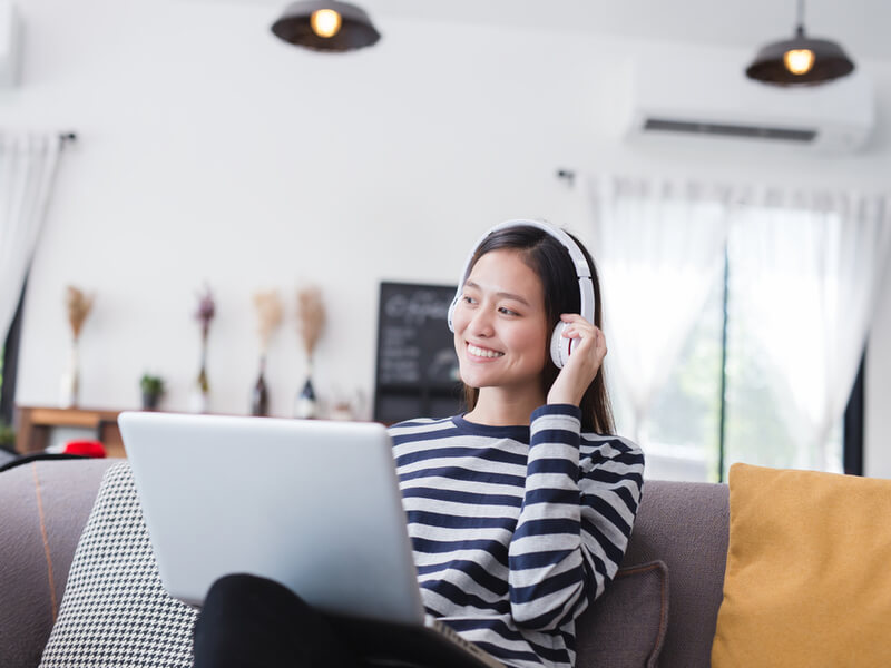 PCの前にヘッドフォンをして座る女性